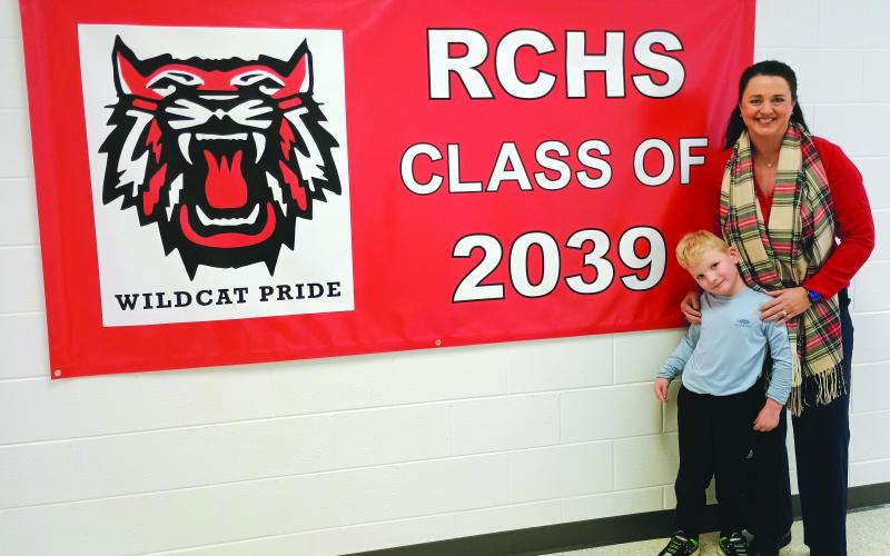 Megan Horn/The Clayton Tribune. Pre-K student Camdyn Darnell, 5, and Rabun County Primary School (RCPS) Principal Carla Truelove pose beside the “RCHS Class of 2039” sign that hangs in the Pre-K hallway. 2026-2027 Pre-K Lottery registration begins March 1 and ends March 13 at 4 p.m.