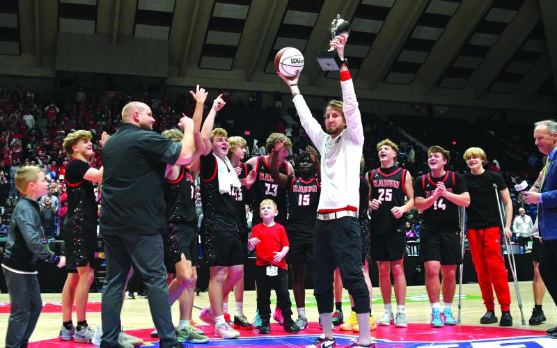 Enoch Autry/The Clayton Tribune. The Rabun County boys basketball team is the Class A Division I state champions for 2026 after capturing the title on March 13 in the Macon Coliseum with a 52-43 victory over Southwest for the first boys hoops championship in the school's history. Here Rabun County head coach David Adcock hoists the trophy and game ball into the air for his team and the crowd to see at midcourt following the triumph.