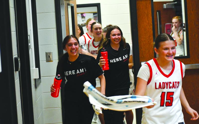 Wesley Branch/The Clayton Tribune. The Rabun County girls basketball team chases after head coach DeeDee Dillard with water bottles after Dillard sprinted out of the locker room back onto the court, following Rabun County’s 56-43 win over Model at home in the Sweet 16 on Feb. 27 to advance to the Elite Eight against Thomasville.