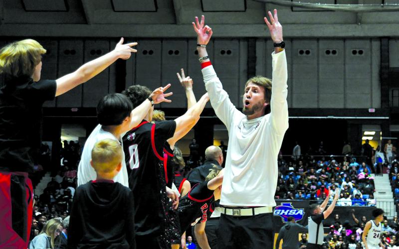 Enoch Autry/The Clayton Tribune. Rabun County boys basketball head coach David Adcock and his Wildcat bench celebrate a 3-point shot by senior Huey Blalock in the 52-43 win on March 13 for the Class A Division I state championship.