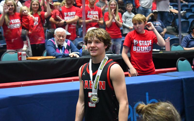 Wesley Branch/The Clayton Tribune. With supportive fans who made the Friday the 13th drive to Macon, senior Huey Blalock smiles wearing his game MVP medal for this 29-point effort in the Wildcats’ state title win.