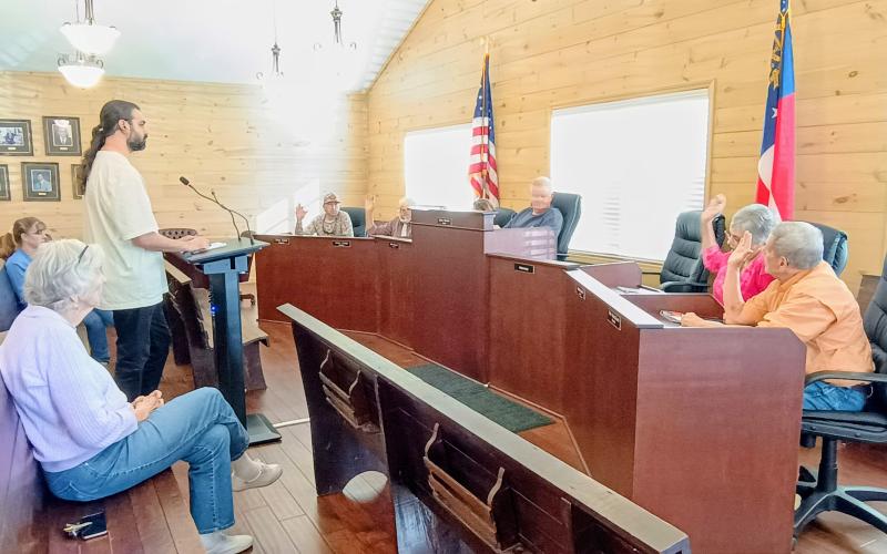Megan Horn/The Clayton Tribune. Tiger Town council members unanimously vote March 9 to approve a rezoning request from Residential to Commercial at 26 Bridge Creek Rd. in Tiger. The property is adjacent to the Tiger Biscuit Place (BP) General Store. The purpose of the rezoning is to add gas pumps at the Tiger four-way intersection. Pictured center is Alim Dhanani, owner of Tiger BP. The other owner is Aslam Dhanani.