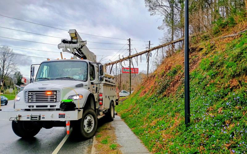 Megan Horn/The Clayton Tribune. Clayton Police Department officers and Georgia Power workers remove a tree that fell on power lines in the area of Ga. 15 at O’Reilly Auto Parts on the morning of March 12.