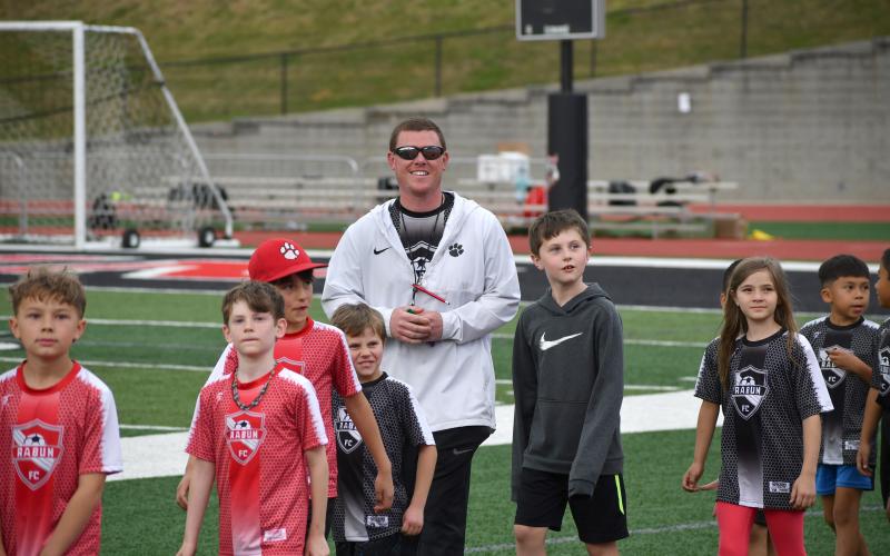 Wesley Branch/The Clayton Tribune.  Lady Cats head coach Brad Holcombe walks with recreation department soccer players on “Rec Night.”