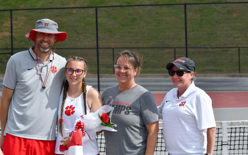 Wesley Branch/The Clayton Tribune.  Rabun County senior Caroline Marshall poses with Rabun County tennis coaches Bryan Getty (left), Jennifer Ramey and Laura Quinn after being recognized on senior night before RCHS’ match versus Commerce on April 2.