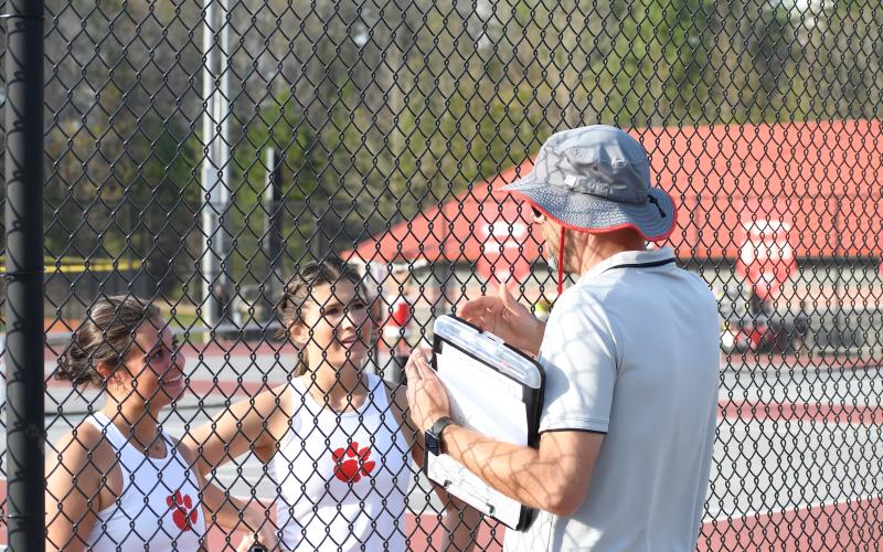 Wesley Branch/The Clayton Tribune. Rabun County head tennis coach Bryan Getty talks with doubles pairing Ella Weber (far left) and Gracie Dunn during their match versus Commerce on April 2. The Lady Cats finished the regular season with a 9-7 record.