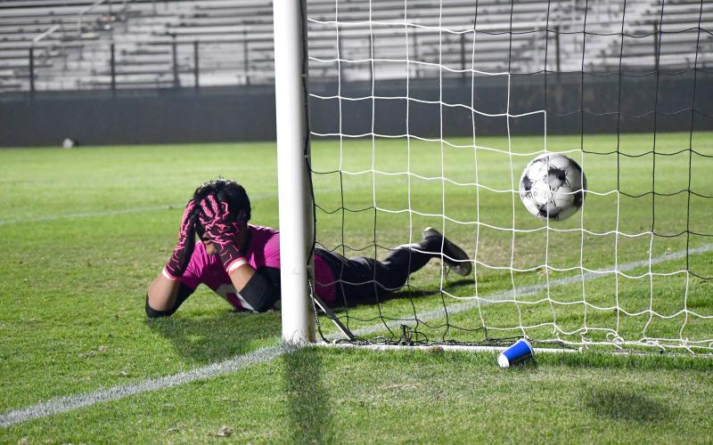 Wesley Branch/The Clayton Tribune. Rabun County senior goalkeeper Chris Olvera lies on the ground in disbelief after narrowly missing saving Athens Academy’s penalty shot on a diving attempt in Rabun