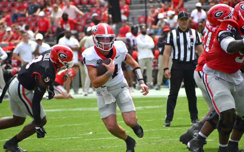 Wesley Branch/The Clayton Tribune. Current UGA and former Rabun County quarterback Gunner Stockton evades defensive pressure from the Black Team in Georgia’s ‘G-Day’ scrimmage. Stockton finished the afternoon 7-of-12 passing for 76 yards and a touchdown for the red team in a 27-17 victory.