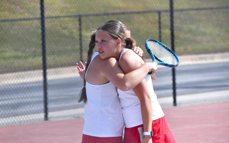 Wesley Branch/The Clayton Tribune. Rabun County’s Jewels Hutcheson and Caroline Marshall embrace after their win on No. 2 doubles over Dodge County in the first round of the state playoffs on April 21 at Rabun County High School. Rabun County will face No. 1 seed Jeff Davis in the second round next week.