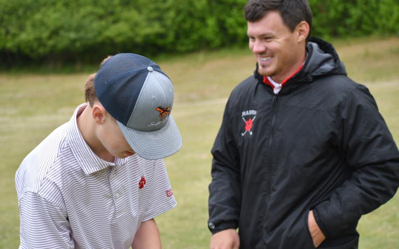 Wesley Branch/The Clayton Tribune. Rabun County head golf coach Wes Holcombe and sophomore Graham Anderson talk in between holes during the area golf tournament at Chimney Oaks in Homer on April 27. The Wildcat boys finished fourth in the tournament.