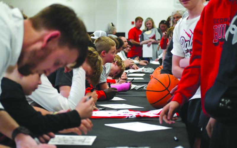 Wesley Branch/The Clayton Tribune. The Rabun County boys basketball team signs autographs for community members at the team’s state championship celebration at Rabun County High School on March 26. The Wildcat boys basketball program won its first state title on March 13 with a 52-43 Class A Division I win over Southwest in the Macon Coliseum.