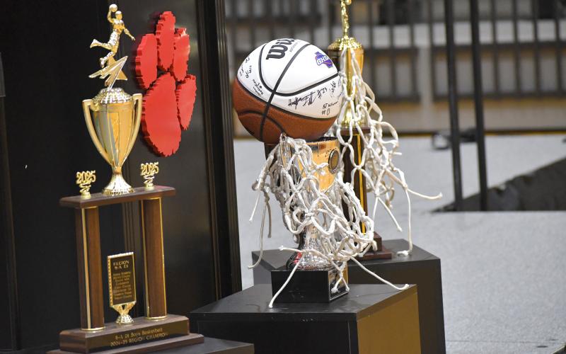 Wesley Branch/The Clayton Tribune. After the basketball net was ceremoniously cut down by the Wildcats on March 26, head coach David Adcock hung it over the Class A Division I state championship trophy.