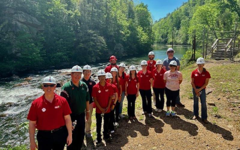 Submitted photo. With Rick Story in the foreground, the Forward Rabun Youth Leadership members stand beside the  Tallulah River at the Gorge Hydroelectric Generating Plant on April 14.