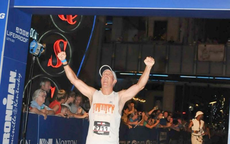 Submitted photo. Mark Holloway reacts to completing an Iron Man competition in Louisville, Ky. He will run the New River Marathon in Todd, N.C.,in May to raise up to $10,000 for Women of Worth and its first class of its recovery program.