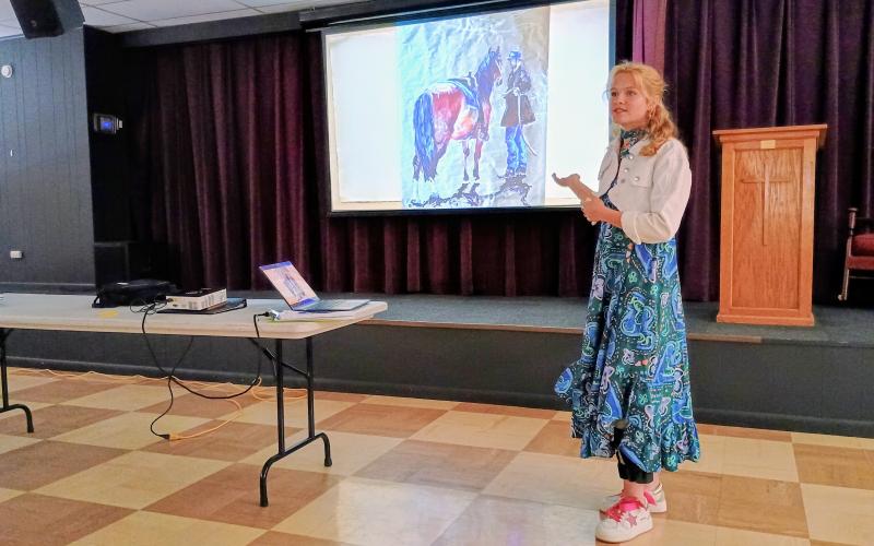 Megan Horn/The Clayton Tribune.  Rabun Gap-Nacoochee School senior Kendall Weisser showcases her artwork at the North Georgia Arts Guild Scholarship meeting on April 16. Weisser received the Paula Van Huss Memorial Scholarship. She said she plans to attend Savannah College of Art and Design (SCAD) to study classical arts and fashion.