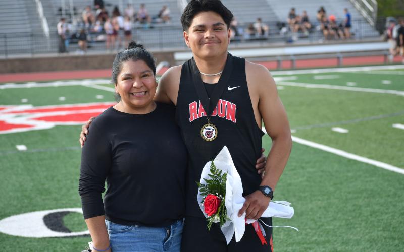 Photo by Wesley Branch/The Clayton Tribune.  Rabun County senior Chris Olvera poses with his mother after senior night festivities at the Bo James invitational at Rabun County High School on April 2. Olvera qualified for the state championship 400 meter dash, recording a time of 52.64 at the sectional meet at Bremen High School on May 4.