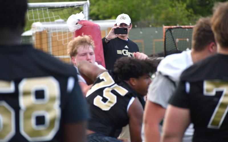 Wesley Branch/The Clayton Tribune. Georgia Tech offensive line coach Allen Mogridge films during the offensive line versus defensive line one-on-ones portion of the Rabun Gap spring college coaches social on May 7 at Rabun Gap’s campus.
