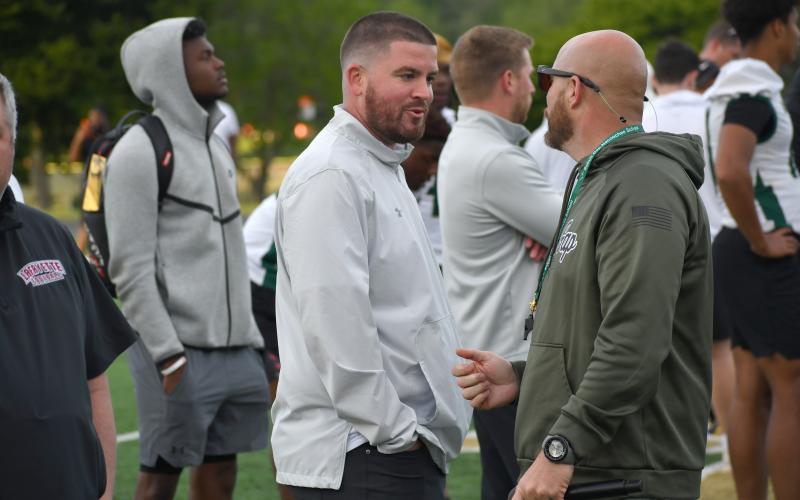 Wesley Branch/The Clayton Tribune. Rabun Gap head football coach Derek White (right) talks with South Carolina linebackers coach Trey Money during the Rabun Gap spring college coaches social on Rabun Gap’s campus May 7. White and Rabun Gap have held two coaches socials in 2026 for high school players to compete in front of college coaches.