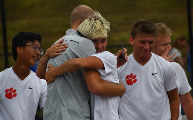 Wesley Branch/The Clayton Tribune. Rabun County junior Cobe Smith hugs RCHS head tennis coach Bryan Getty after the Wildcats’ win in the Final Four against Model on May 8. Smith is 17-1 this season on No. 3 singles.