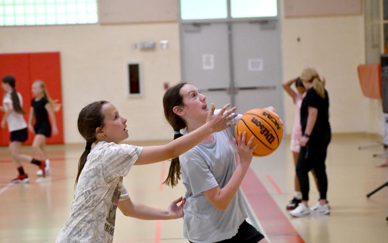 Wesley Branch/The Clayton Tribune. Lauren Henson (left) defends as fellow Lady Cats camper Sarah Smith drives to the basket during the one-on-one competition of the Lady Cats basketball camp.