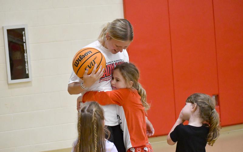 Wesley Branch/The Clayton Tribune. Lady Cats camper Huntlee Henry hugs RCHS varsity Lady Cat Jaydynn Cohee during the Lady Cats basketball camp at the Rabun County rec department on May 11. Cohee was one of several current players assisting with the camp during the week.