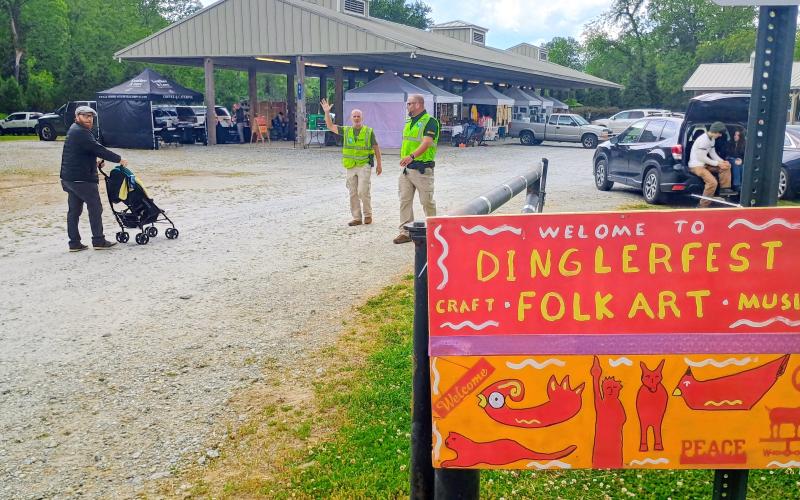 Megan Horn/The Clayton Tribune. Dinglerfest brought many community members for the folk art and live music. This sign was created by Presenter Charlie Dingler, after whom the annual event is named. Pictured are Conner Horn, left, along with Craig Neff and Jeff Lovell of Mountain Lakes Security.
