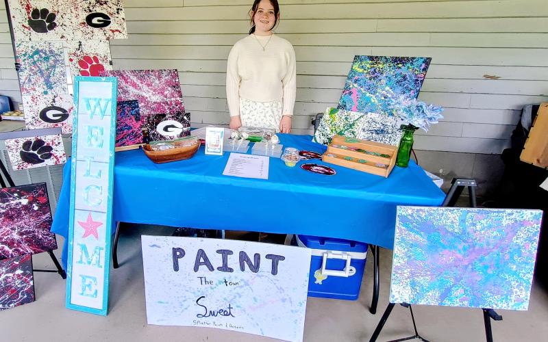 Megan Horn/The Clayton Tribune. Evelyn Raines, 12, with the business “Paint the Town Sweet” was excited to see many visitors to the third annual EdVentures Resource Center Kids’ market last week. The business features paintings and homemade baked goods.