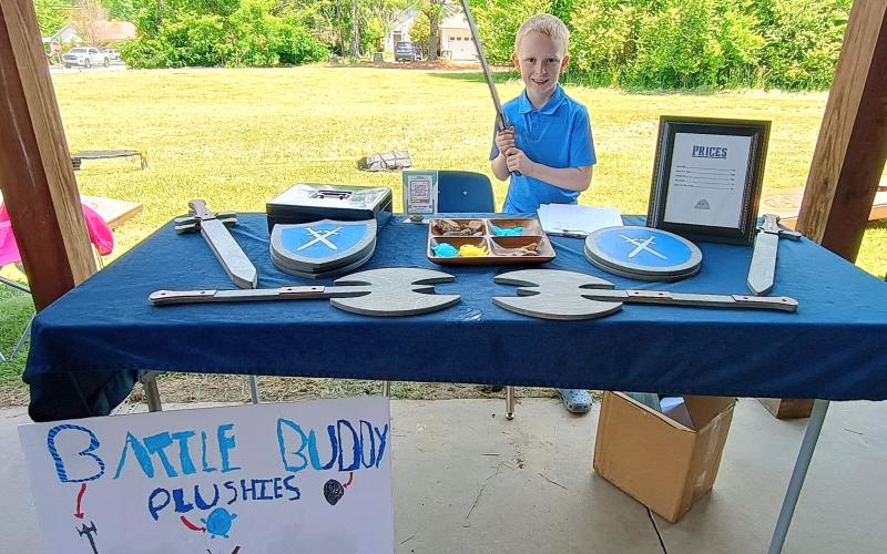 Megan Horn/The Clayton Tribune. Henry Farmer, 8, is ready to sell his Battle Buddy Plushies and other items during the recent EdVentures Kids’ Market. This was the third annual Kids’ Market for the innovative school.