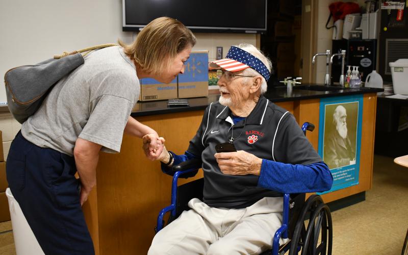 Megan Horn/The Clayton Tribune. Rabun County High School Class of 1989 Kelli Marcus Wayne shares words of heartfelt gratitude with former science teacher Clayton Croom, 97, in his old classroom during the May 16 walkthrough down memory lane. Wayne told Croom that he was an inspiration for her.