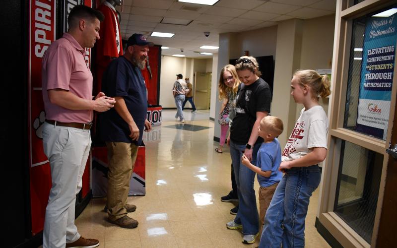 Megan Horn/The Clayton Tribune. Kayla Reid, RCHS Class of 2009, and her children Millie, 13, Briana, 12, and Sam, 5, walk through the current Rabun County High School Building during the May 16 walkthrough. They are greeted by RCHS Principal Justin Spillers and Shane Taylor, left. Starting next year, high school students will be housed at the Academic Center.