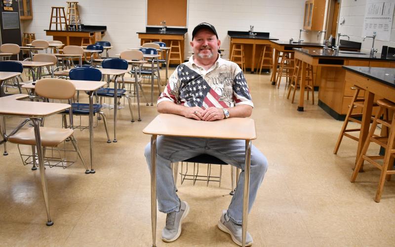 Megan Horn/The Clayton Tribune. Stanley Beasley sits at a desk in science teacher Clayton Croom’s old classroom during the May 16 walkthrough at Rabun County High School. Beasley graduated in the Class of 1988.