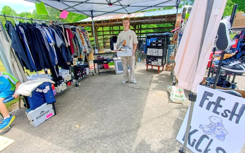 Megan Horn/The Clayton Tribune. Kamden Treff, 17, sells shoes and clothing out of his business called “Fresh Kicks” during last weekend’s Kids’ Market.