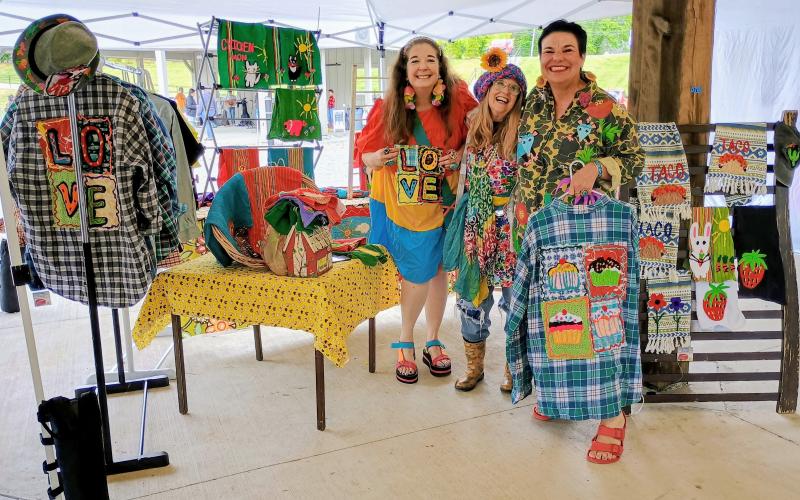 Megan Horn/The Clayton Tribune. Dinglerfest featured some of the best folk artists in the region, including Mavis Stevens (center) who is a folk artist specializing in Fiber Art. Her business is called “Last Chance Trailer Park.” Traci Sampson, left, and Anita Shegog are big fans of the folk artist. Shegog referred to Stevens as a folk art legend.