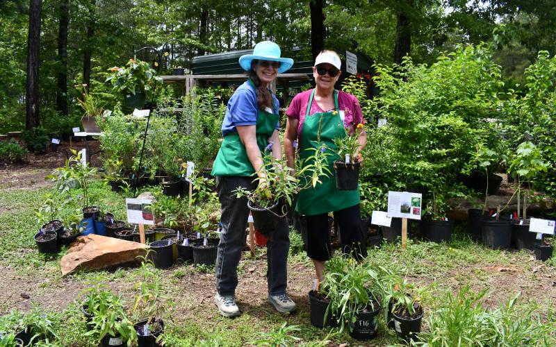 Megan Horn/The Clayton Tribune. Lynn McShane, Headwaters Master Gardeners expert, and Tammy Schober, an intern with Headwaters Master Gardeners, tend to plants and help assist customers with information during last week’s Spring Plant Sale at Victory Home in Tallulah Falls.