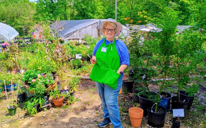 Megan Horn/The Clayton Tribune. Master Gardener Beth Suggs said she loves contributing to the community and finds that there is “a lot of camaraderie” in being part of the Headwaters Master Gardeners Association. Suggs enjoys helping customers at last week’s Victory Home Greenhouse Spring Plant Sale.