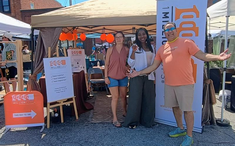 Megan Horn/The Clayton Tribune. Tina Story, Veronica Respress and Bez Rengifo with 1 Million Cups talk to visitors at the 2026 Ramshackle in downtown Clayton on Saturday, June 6.