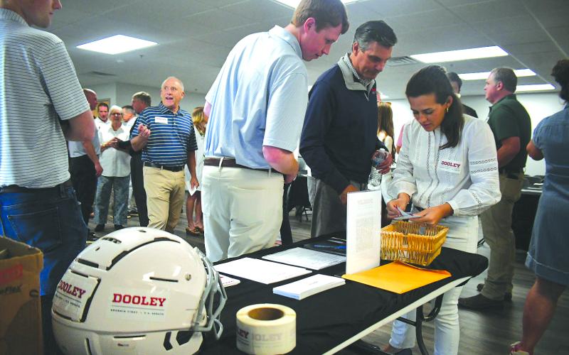 Enoch Autry/The Clayton Tribune. With the assistance of his campaign staff, former football coach Derek Dooley (right) looks through pieces of paper with the names of those in attendance.