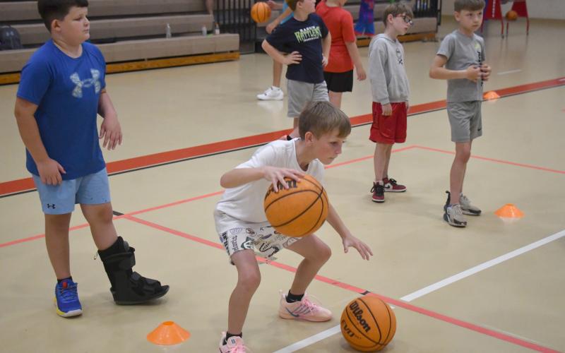 Wesley Branch/The Clayton Tribune. Campers worked on their ball-handling, passing and other fundamentals at the camp. RIGHT: Campers pose for a photo at the Rabun County basketball camp at the Rabun County Recreation Department on June 2. The camp ran for three days for kids aged kindergarten through seventh grade.