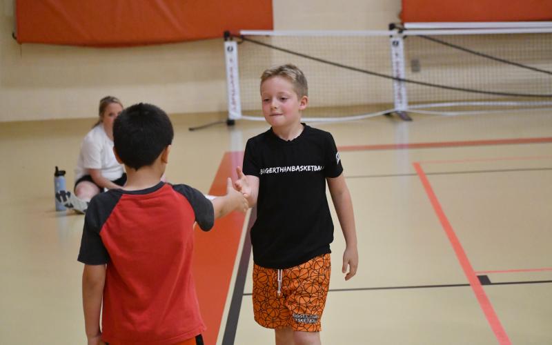 Wesley Branch/The Clayton Tribune. Reeves Page (background) shakes hands with another camper after a competition at the Rabun County basketball camp at the Rabun County Recreation Department on June 2. Page is the son of assistant coach Corey Page.
