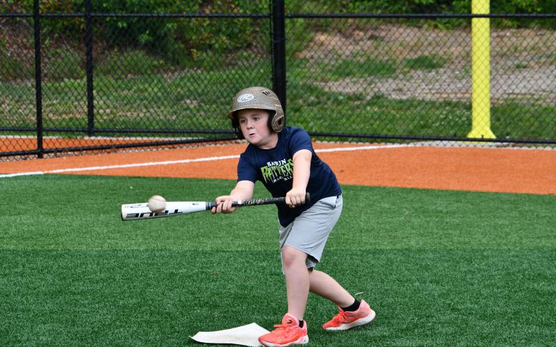 Wesley Branch/The Clayton Tribune. Campers at the RCHS Baseball camp this week practiced laying down bunts as well as other fundamentals of baseball. In this photo, one of the campers focuses intently on his bunt attempt.