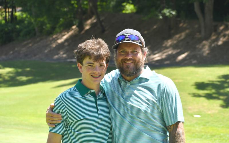 Wesley Branch/The Clayton Tribune. Brandon English (right) poses with his son Maddox English during the Wildcat Open golf tournament at Kingwood Golf Club on June 15. The English family made up one of the 16 total teams in the inaugural tournament.