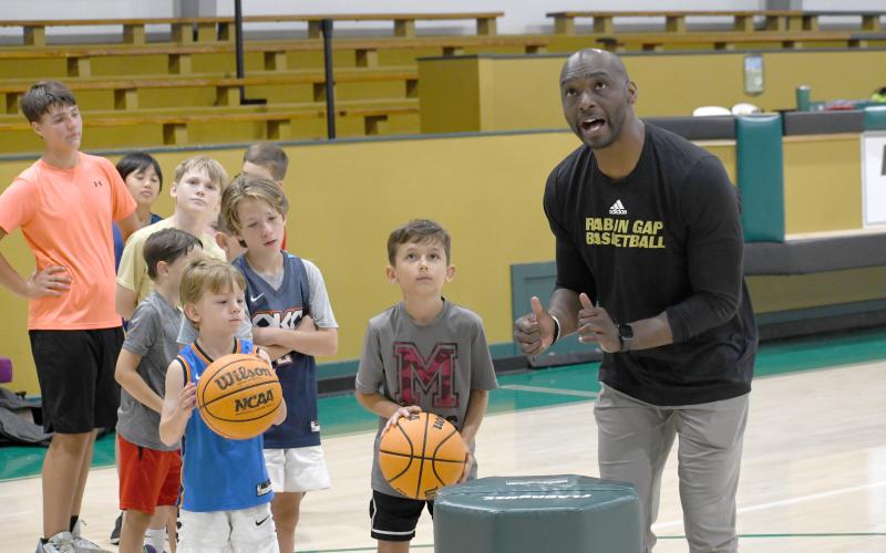 Wesley Branch/The Clayton Tribune. Rabun Gap-Nacoochee School head boys basketball coach Devin Liferidge leads campers in shooting drills during Rabun Gap’s kids basketball camp on June 8. Liferidge is entering his second season as the head boys basketball coach for the Eagles.