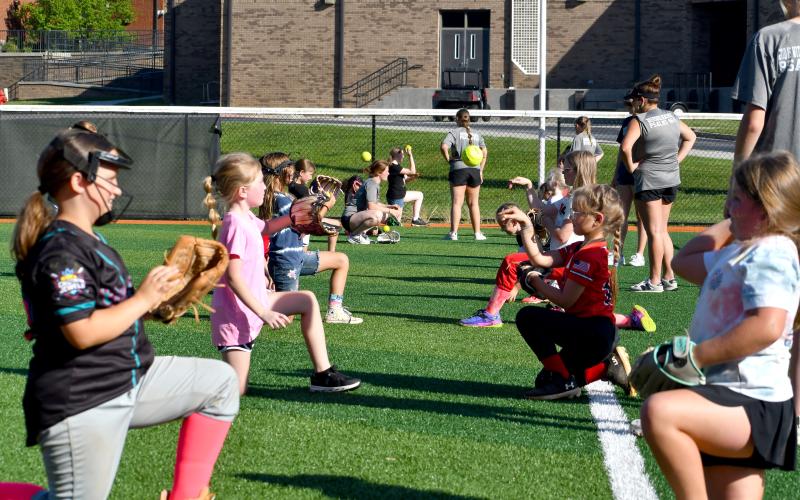 Wesley Branch/The Clayton Tribune. RCHS softball campers throw the ball to each other to warm up during the Rabun County softball camp at Rabun County High School on June 15. The camp was offered to kids aged 5-12 years old