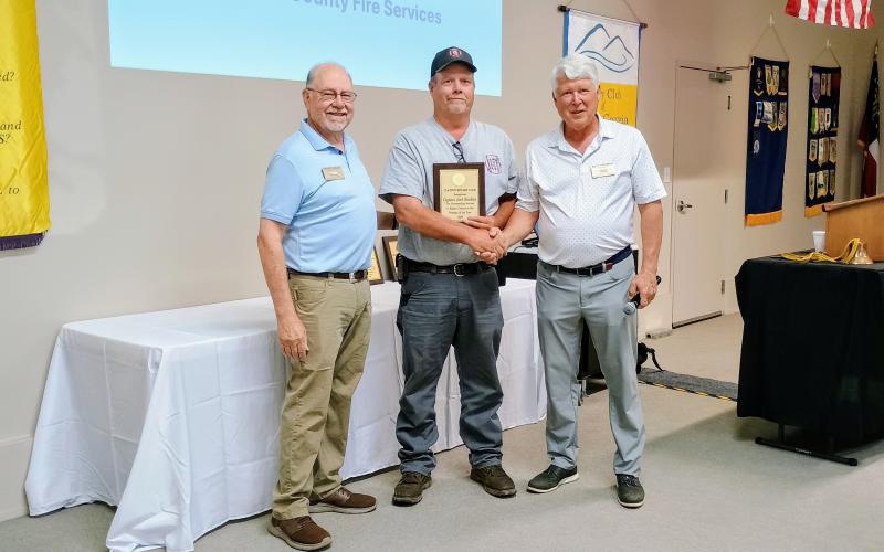 Megan Horn/The Clayton Tribune. The Rotary Club of Clayton recognized Rabun County Fire Services Captain Josh Bleckley, pictured center, as the 2026 Fireman of the Year for his outstanding service to Rabun County. Rotarian Stewart Harvard and Rotary Club of Clayton President Matt Freeman shake hands with Bleckley during the Thursday, June 4, lunch meeting.