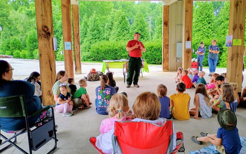 Megan Horn/The Clayton Tribune. Wildland Firefighter Thomas with the U.S. Forest Service talks to kids about fire safety and how to prevent forest fires during a Rabun County Public Library summer program event on Tuesday, June 9.