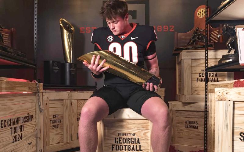 Image via Marcellus_yc on Instagram. Rabun Gap defensive lineman Marcellus Young Casario poses with a national championship trophy during his official visit to Georgia. Casario announced his commitment to the Bulldogs on June 15.