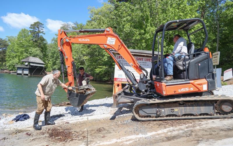 Submitted. Volunteers scoop up debris during the May 8 Lake Burton Cleanup day. In the spirit of friendly competition, the Lake Burton Civic Association has awarded a trophy to the crew that brought back the most debris.