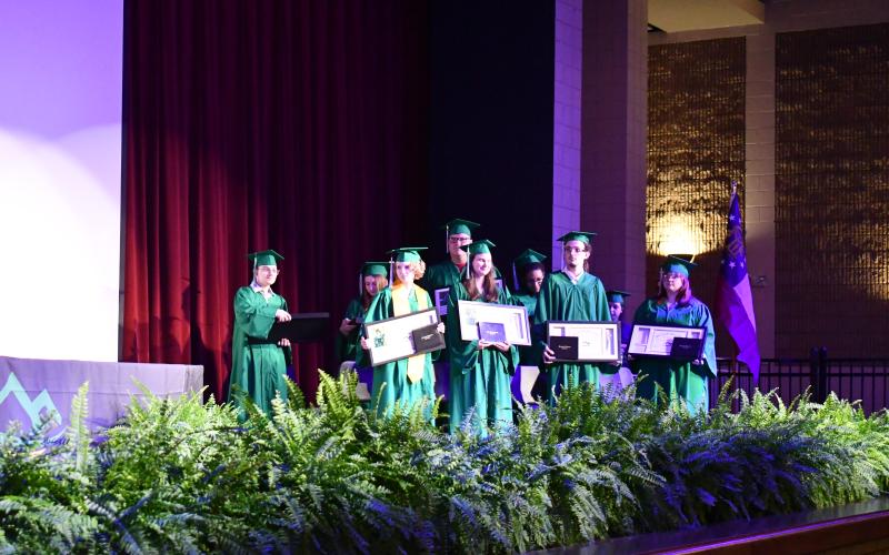 Megan Horn/The Clayton Tribune. Graduates in the Rabun Mountain Education Class of 2026 are excited to hold their diplomas after walking in their graduation ceremony held on Saturday, May 23, at the Rabun County High School Fine Arts Building. There were 12 students who graduated and nine who participated in the ceremony.