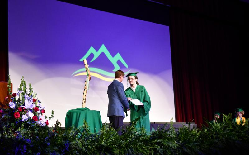 Megan Horn/The Clayton Tribune. Ryan Douglas Wayne Eker receives his high school diploma and shakes hands with Rabun Mountain Education Campus Principal Allen Blair during the Rabun Mountain Education graduation ceremony on May 23.