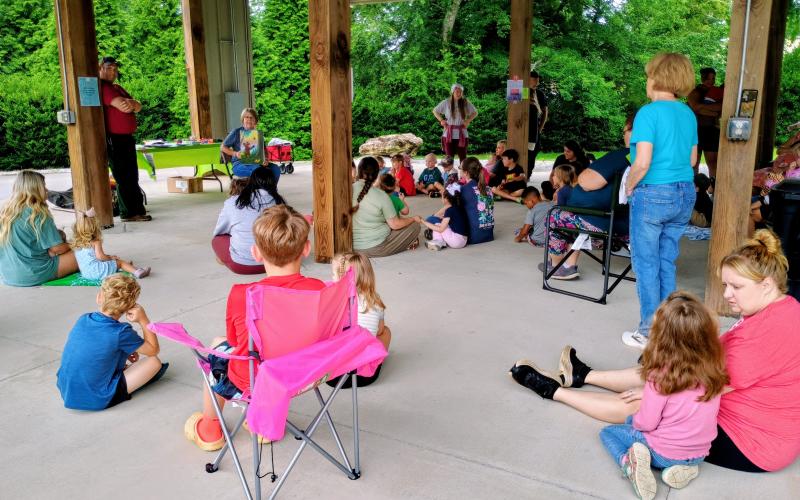 Megan Horn/The Clayton Tribune. Kim Cannon reads the story of Smokey Bear to kids at the  Storytime with Mrs. Kim at the Rabun County Public Library’s Tuesday program was a success with 96 attendees. Kim Cannon works with youth services at the library.